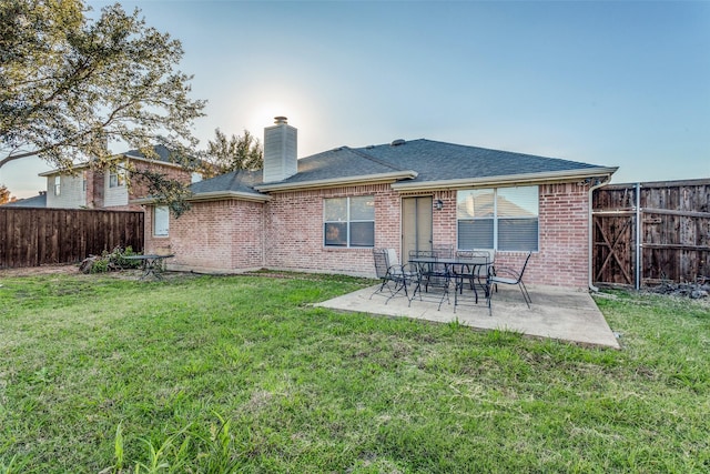 back of house featuring a patio area and a lawn