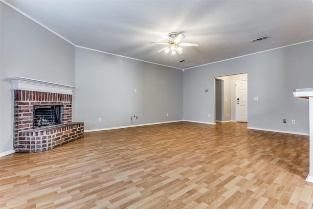 unfurnished living room featuring crown molding, ceiling fan, a fireplace, and light hardwood / wood-style flooring