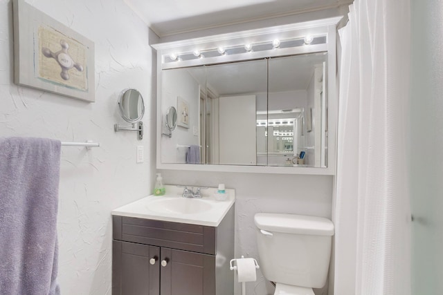 bathroom with a shower with shower curtain, vanity, toilet, and ornamental molding