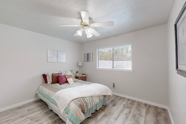 bedroom featuring ceiling fan, a textured ceiling, and light hardwood / wood-style flooring