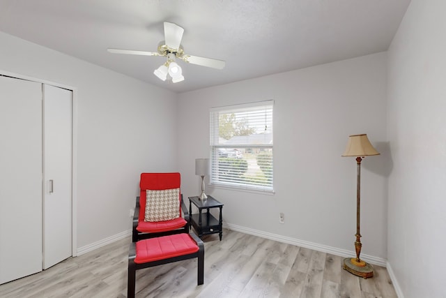 living area featuring light hardwood / wood-style floors and ceiling fan