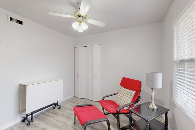 living area with ceiling fan and light wood-type flooring