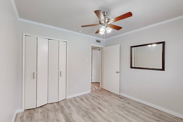 unfurnished bedroom featuring ceiling fan, a closet, light hardwood / wood-style floors, and ornamental molding