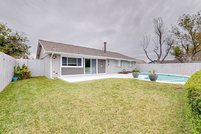 back of house featuring a yard, a fenced in pool, and a patio