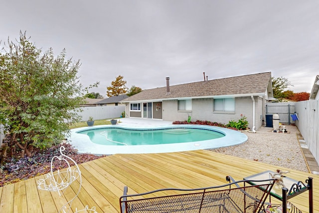 view of swimming pool featuring a wooden deck and central AC unit