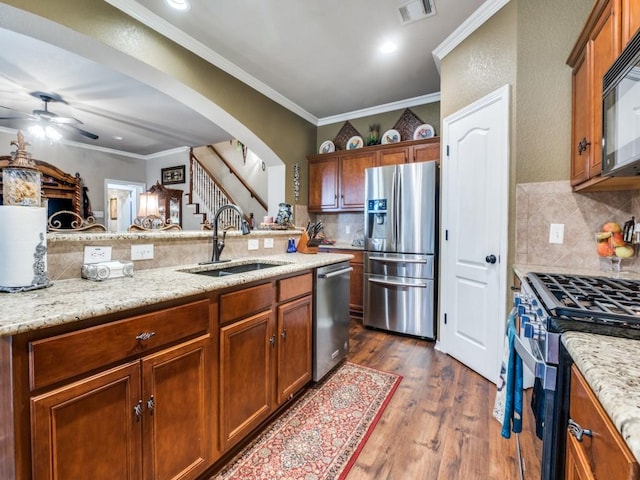 kitchen featuring dark hardwood / wood-style flooring, ornamental molding, sink, and appliances with stainless steel finishes