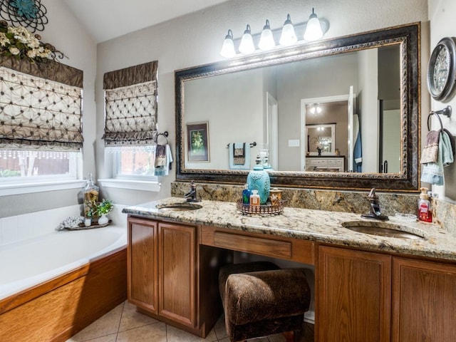 bathroom with tile patterned floors, a tub to relax in, vanity, and lofted ceiling