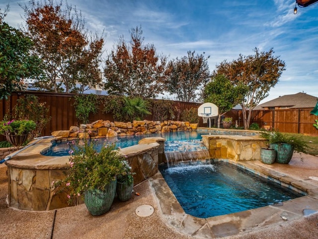 view of pool featuring pool water feature and an in ground hot tub