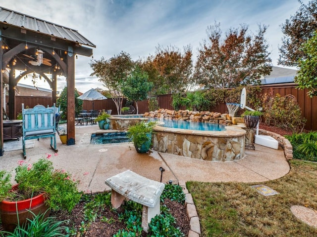 view of patio / terrace with a swimming pool with hot tub