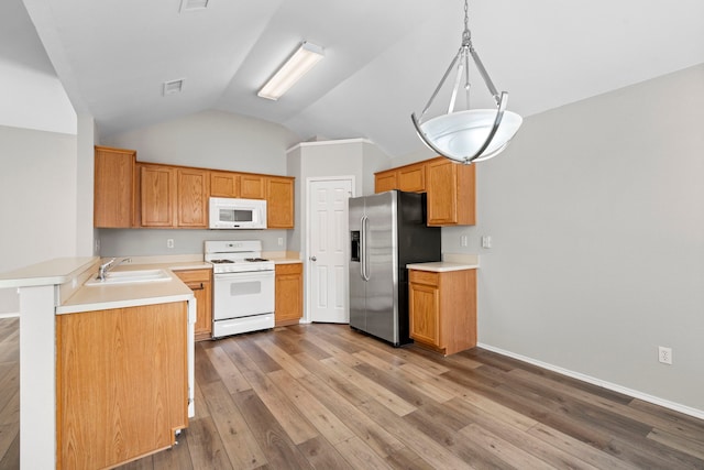 kitchen with white appliances, hanging light fixtures, vaulted ceiling, hardwood / wood-style flooring, and kitchen peninsula