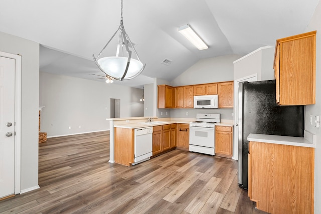 kitchen with white appliances, sink, decorative light fixtures, hardwood / wood-style flooring, and lofted ceiling