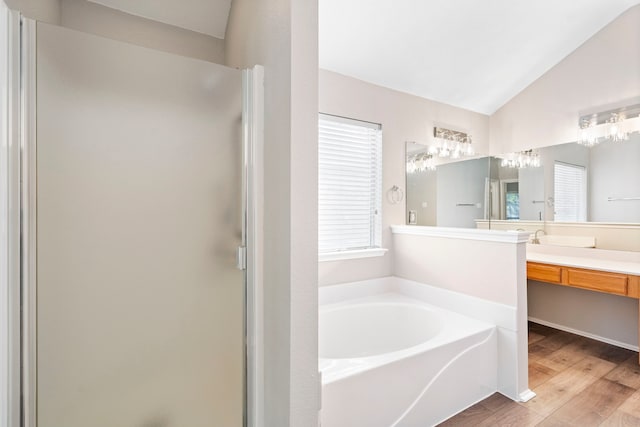 bathroom featuring shower with separate bathtub, plenty of natural light, lofted ceiling, and hardwood / wood-style flooring