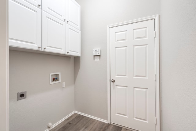 washroom featuring electric dryer hookup, hookup for a washing machine, dark hardwood / wood-style flooring, and cabinets