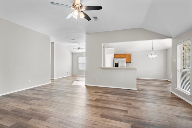 unfurnished living room featuring a wealth of natural light and hardwood / wood-style floors