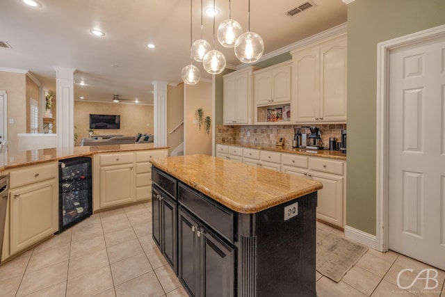 kitchen with ornate columns, crown molding, a center island, and beverage cooler