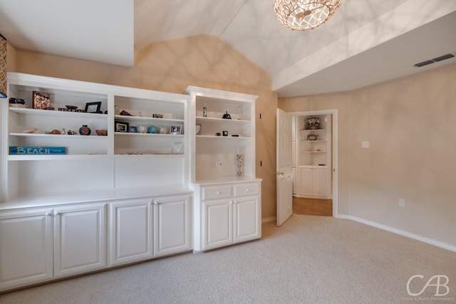 mudroom with light carpet, an inviting chandelier, and vaulted ceiling