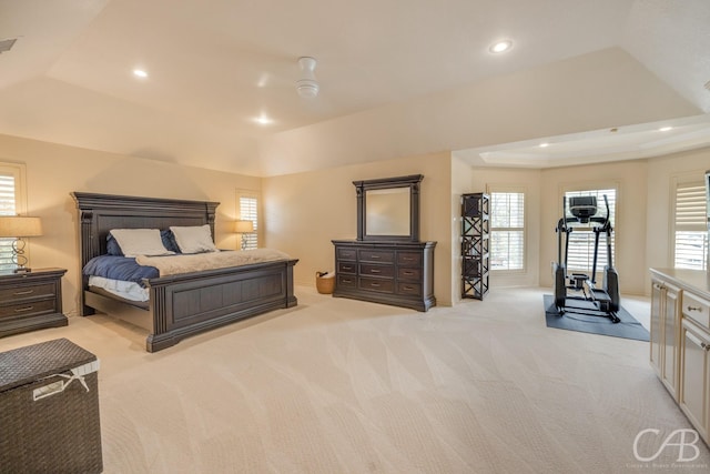 bedroom with ceiling fan, a raised ceiling, and light colored carpet