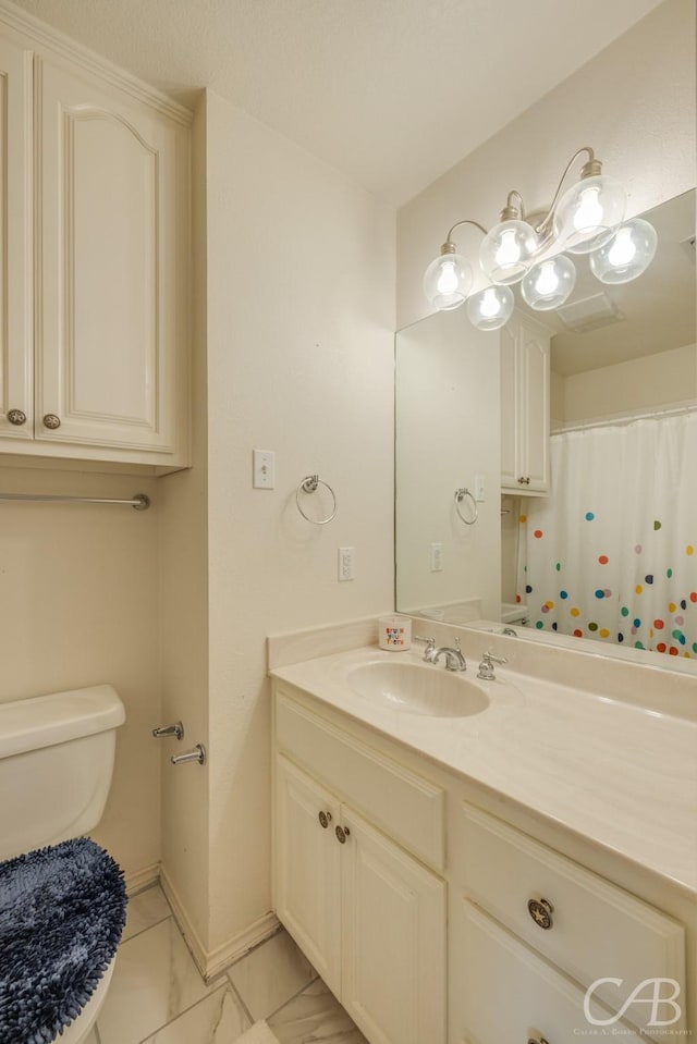 82 Bay Shore Ct, Abilene, TX 79602 - bathroom with toilet, vanity, baseboards, and marble look tile flooring