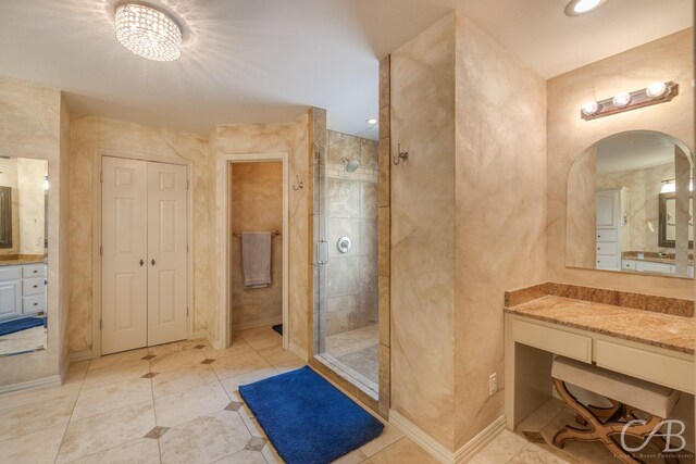 bathroom with tile patterned flooring, vanity, walk in shower, and a notable chandelier