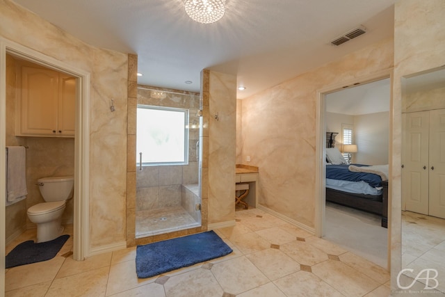 bathroom with tiled shower, tile patterned floors, and toilet