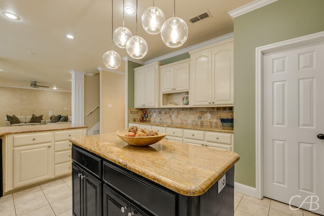 82 Bay Shore Ct, Abilene, TX 79602 - kitchen featuring light tile patterned floors, ornamental molding, a center island, dark cabinetry, and backsplash