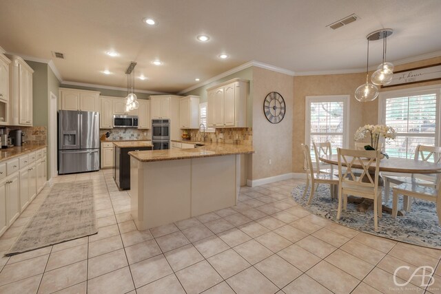 kitchen featuring light stone counters, kitchen peninsula, crown molding, decorative light fixtures, and appliances with stainless steel finishes