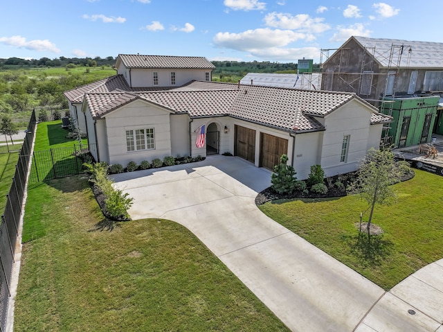 mediterranean / spanish house with a front lawn, central AC unit, and a garage