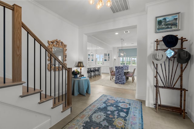 foyer with crown molding and light tile patterned flooring