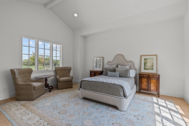 bedroom featuring beamed ceiling, light wood-type flooring, and high vaulted ceiling