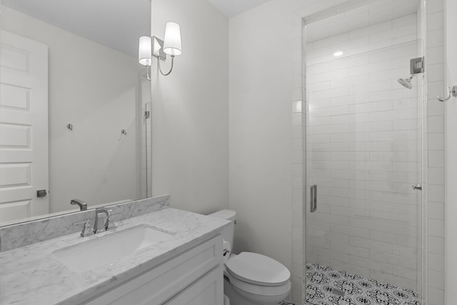 bathroom with a shower with door, vanity, and toilet