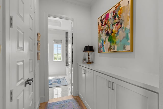 hall featuring light tile patterned floors and crown molding