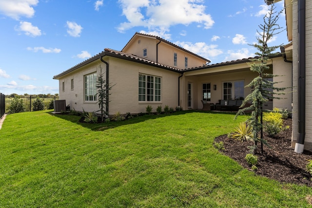 back of property with central AC unit and a lawn