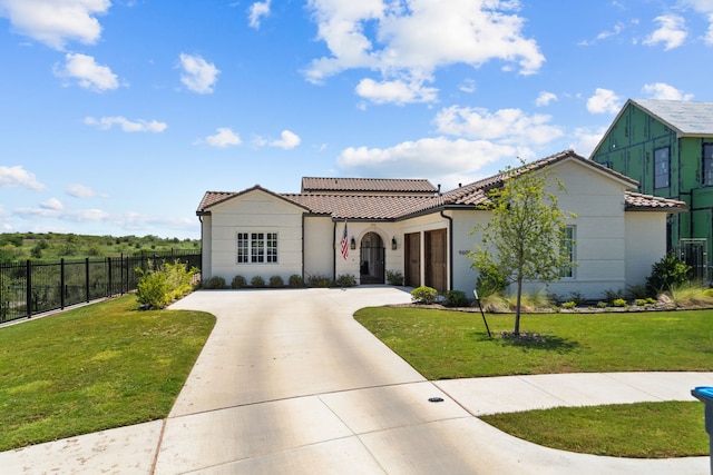 mediterranean / spanish home featuring a front yard and a garage