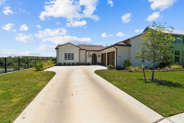 mediterranean / spanish-style house with a garage and a front lawn