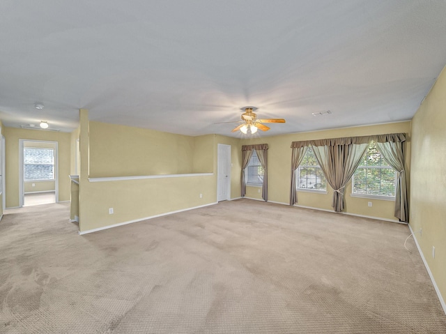 unfurnished room with light colored carpet and ceiling fan