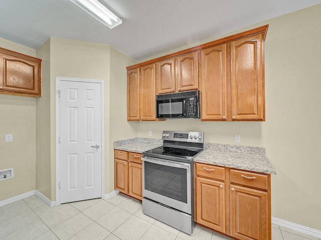 kitchen featuring light tile patterned flooring, light stone counters, and stainless steel electric range