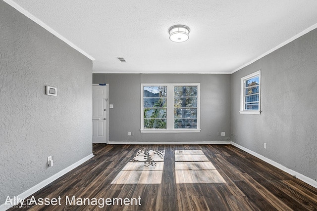 empty room with ornamental molding, dark wood-type flooring, and a wealth of natural light