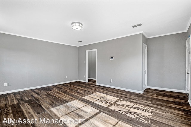 spare room featuring ornamental molding and dark wood-type flooring