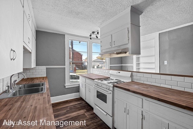 kitchen featuring white cabinetry, sink, butcher block counters, and gas range gas stove