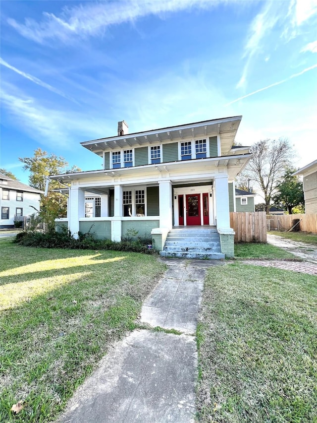 view of front facade featuring covered porch and a front yard