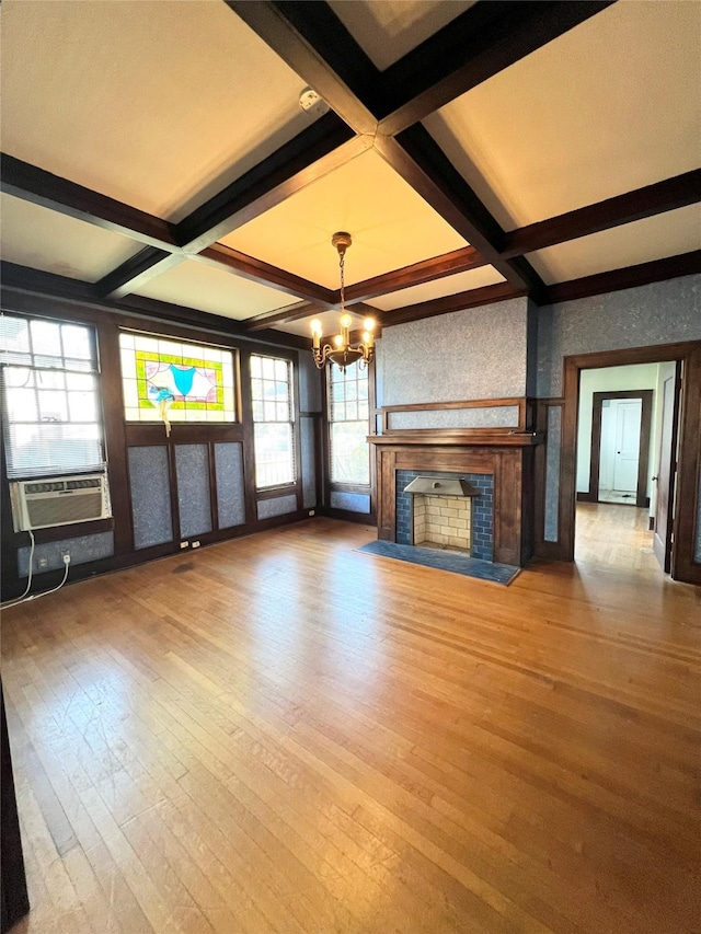 unfurnished living room featuring coffered ceiling, cooling unit, beam ceiling, wood-type flooring, and a chandelier