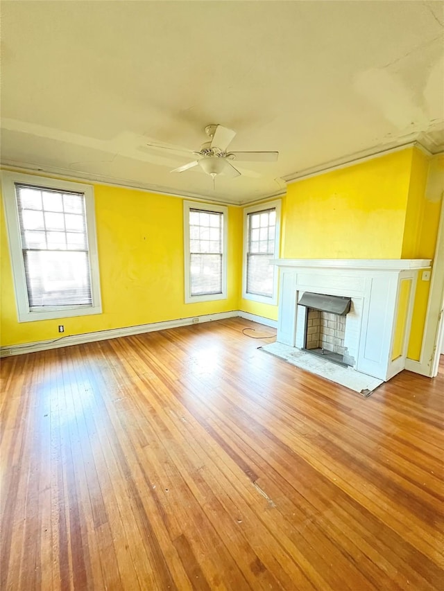 unfurnished living room with ceiling fan, ornamental molding, and light wood-type flooring