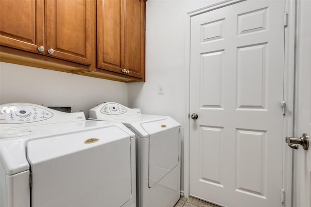 clothes washing area with cabinets, independent washer and dryer, and light tile patterned floors