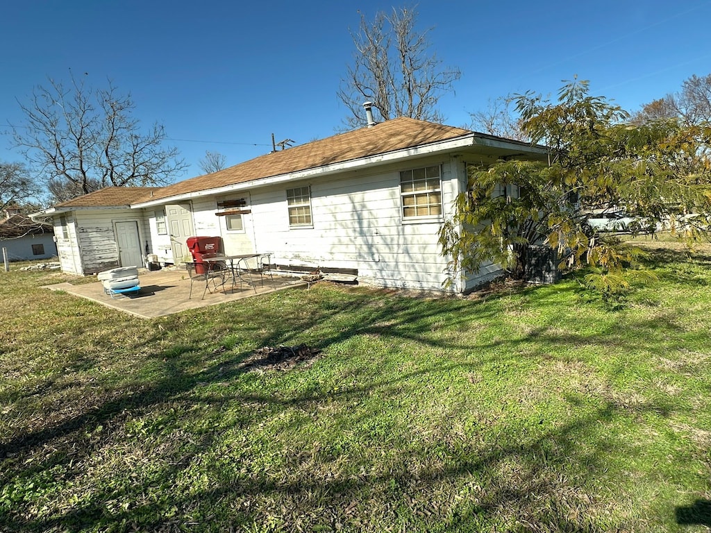 back of house with a yard and a patio