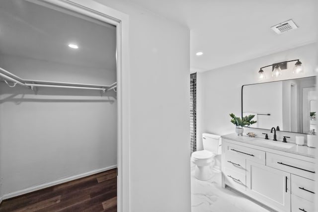 bathroom with hardwood / wood-style floors, vanity, and toilet