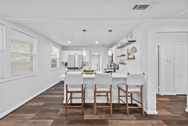 kitchen with pendant lighting, white cabinets, dark hardwood / wood-style flooring, kitchen peninsula, and stainless steel refrigerator