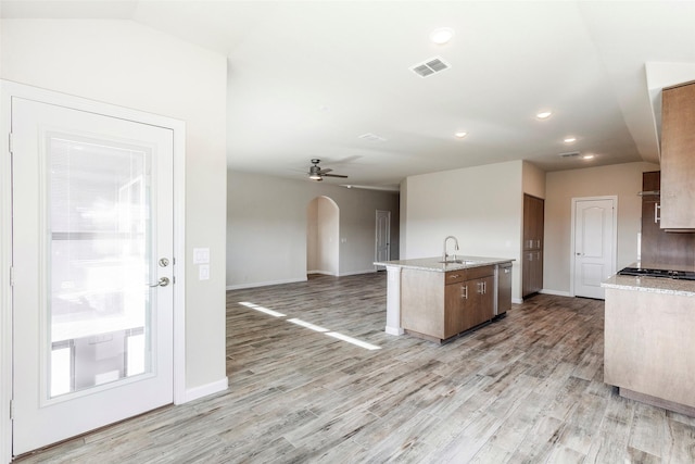 kitchen with dishwasher, a center island with sink, sink, ceiling fan, and light wood-type flooring