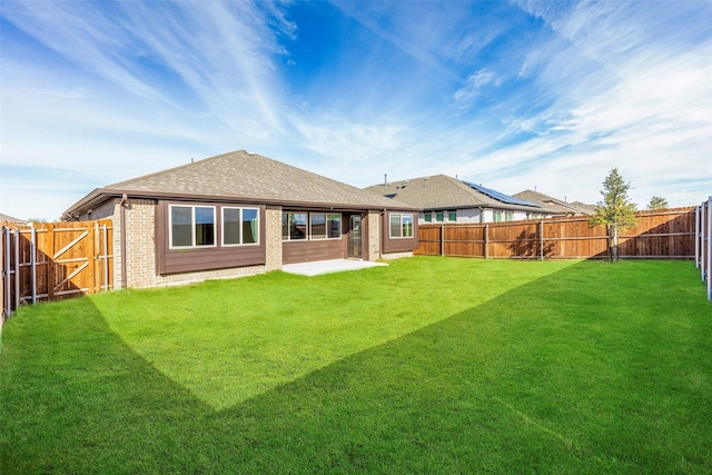 rear view of property featuring a lawn and a patio