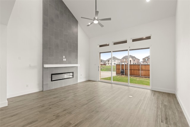 1385 Melcer St, Frisco, TX 75036 - unfurnished living room with high vaulted ceiling, baseboards, a large fireplace, a ceiling fan, and wood finished floors