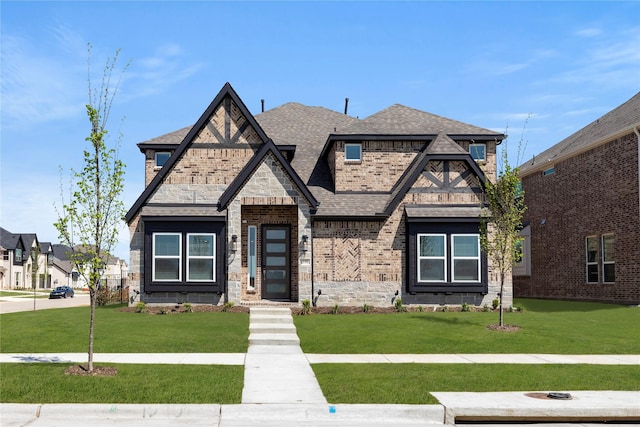 1590 Marburg Ln, Frisco, TX 75036 - view of front of house with a front yard, stone siding, a shingled roof, and brick siding
